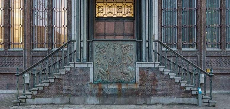 Exterior entrance of the historic Blaak 34 building with stone steps and decorative metalwork.