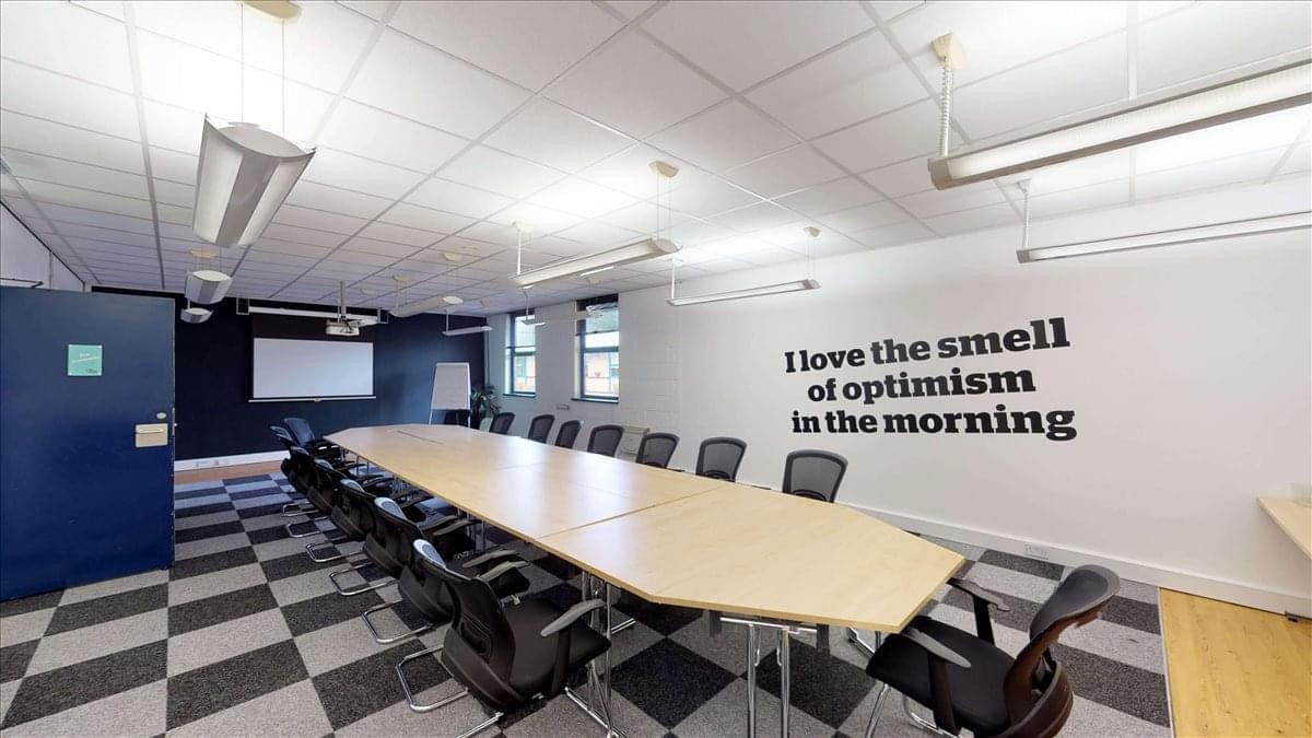 Spacious boardroom at Bow Bridge Close, Rotherham, Yorkshire with a long light-wood table and wall quote.