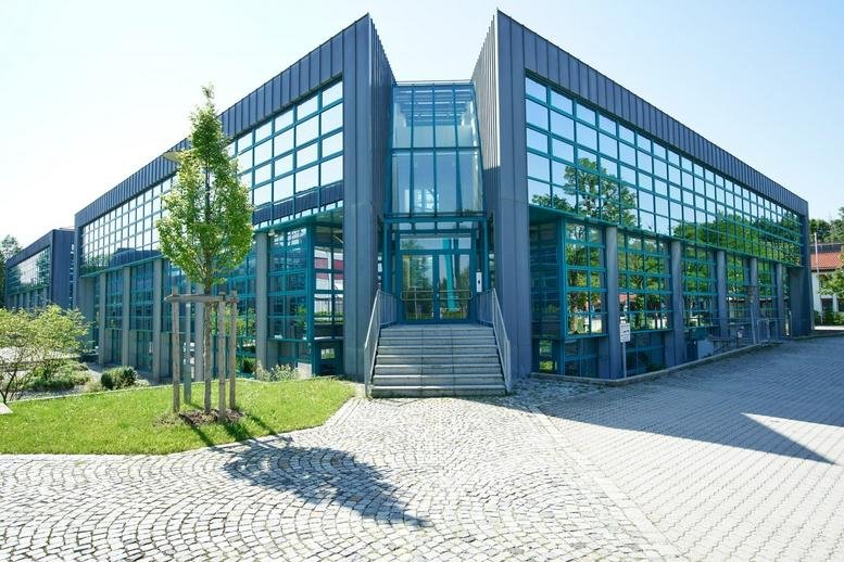 Modern glass-facade exterior of the office building at Bretonischer Ring 4-6a.