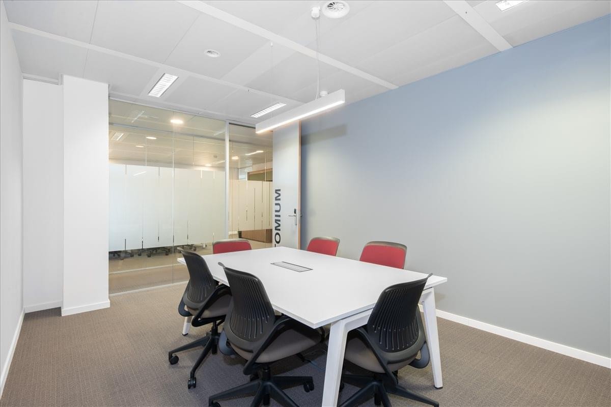 Meeting room at 6th Floor, Bridge Building, 584 Charles-Quint Avenue with red chairs and white table.