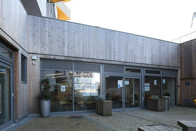 Exterior view of the wood-paneled entrance at Brighton Junction, 1A Isetta Square.