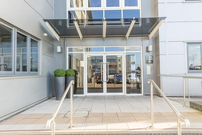 Main entrance of Pure Offices at Broadwell Road featuring glass doors and a modern canopy.