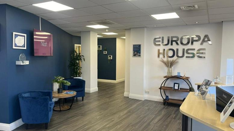 Reception area for Business Lodge, Europe House, Barcroft Street with blue feature wall and velvet armchairs.