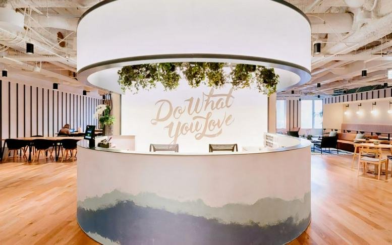 Modern circular reception desk with the phrase Do What You Love on the back wall.