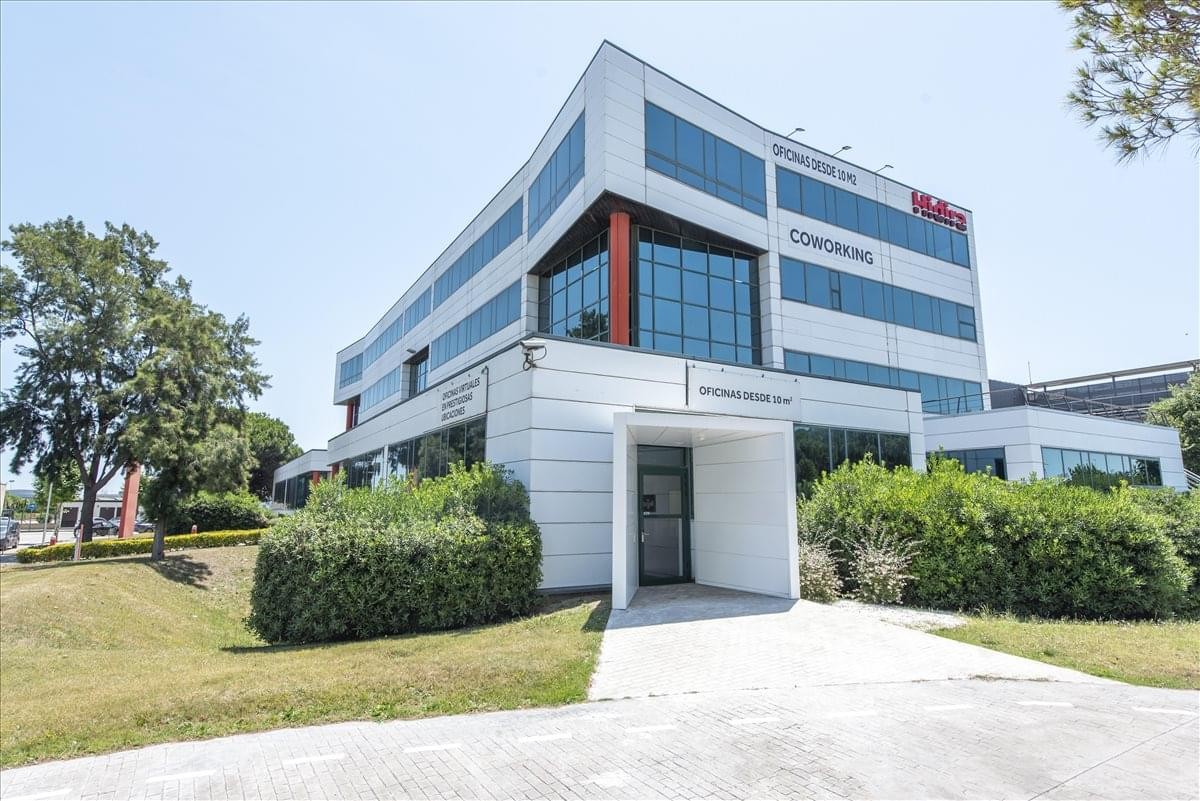 Exterior view of the modern Mas Blau Centre office building with a white facade and large windows.