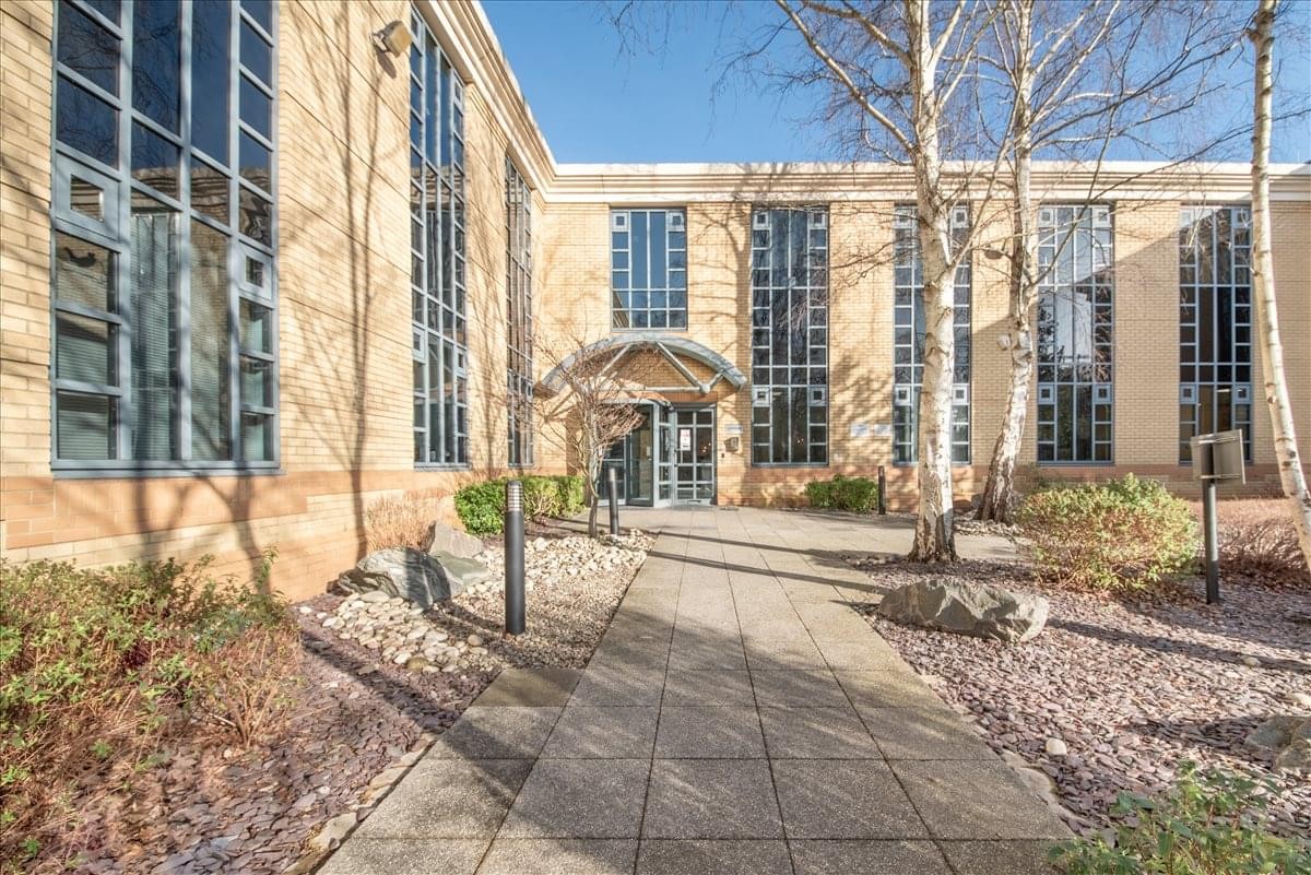Exterior view of the tan stone facade and glass entrance of Centaur House.