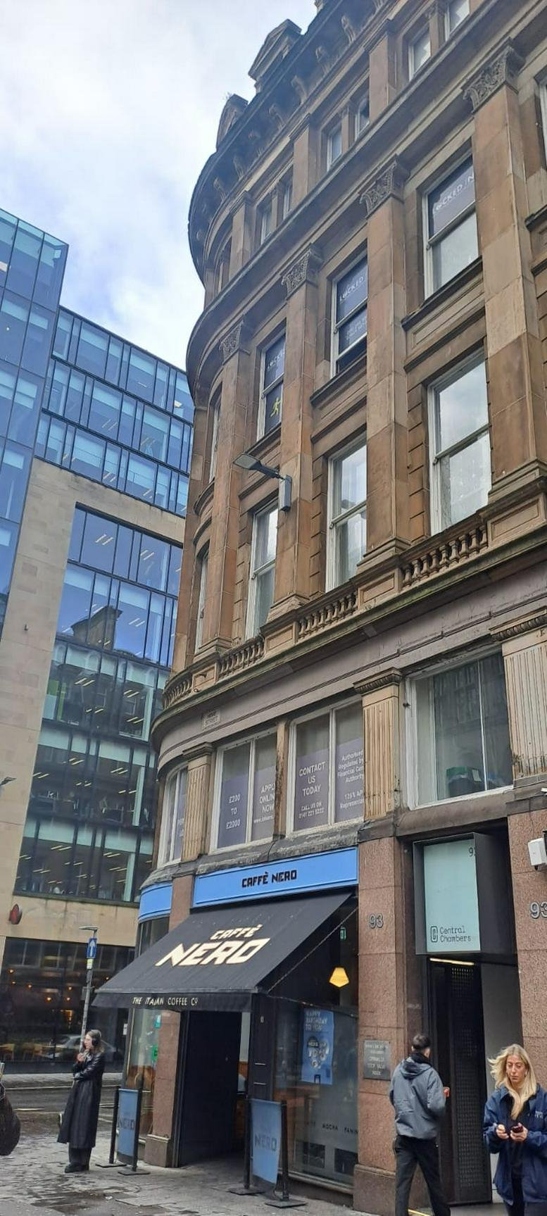 Exterior view of the ornate stone facade of Central Chambers, featuring a Caffe Nero at street level.