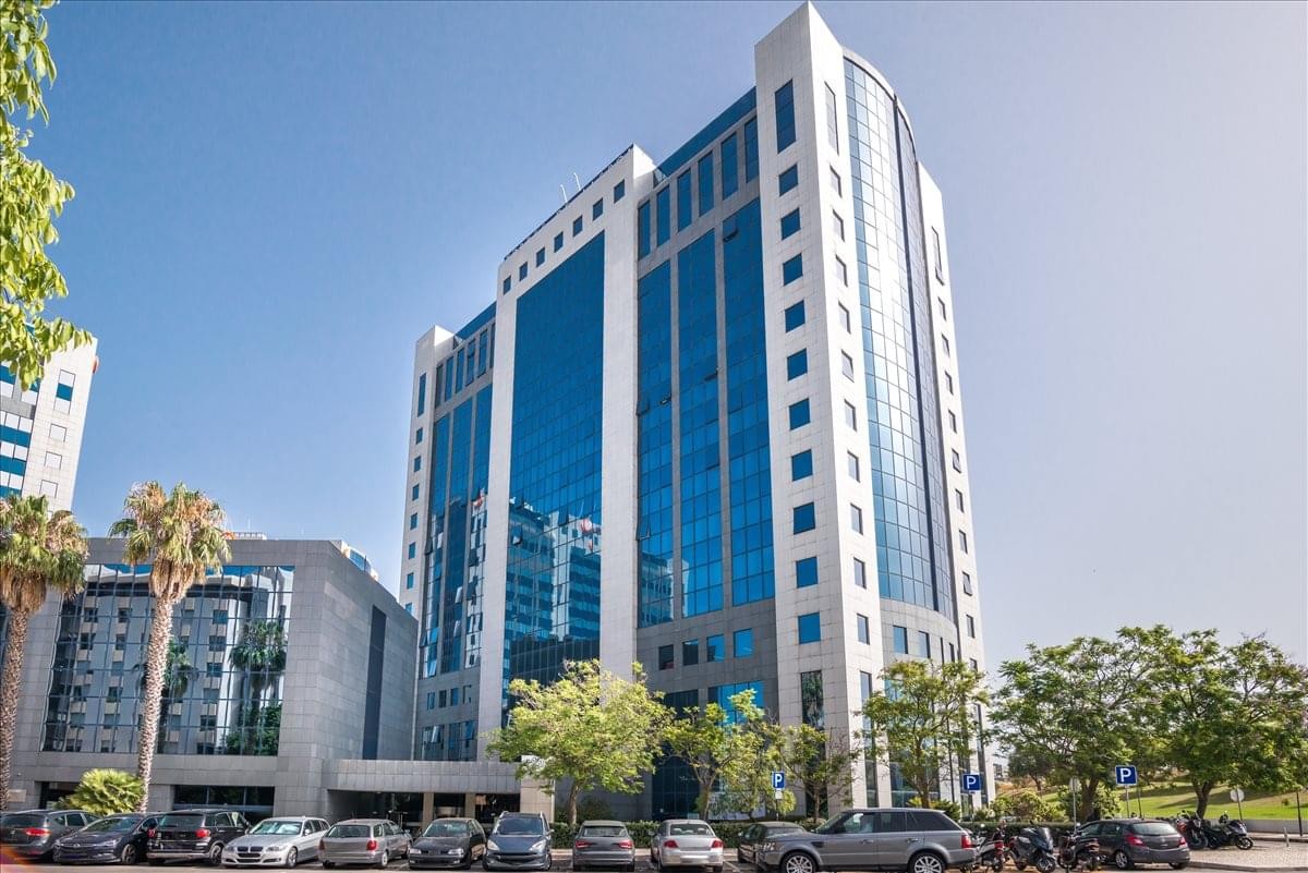 Wide exterior shot of the blue glass Centro Empresarial Torres de Lisboa building under a clear sky.