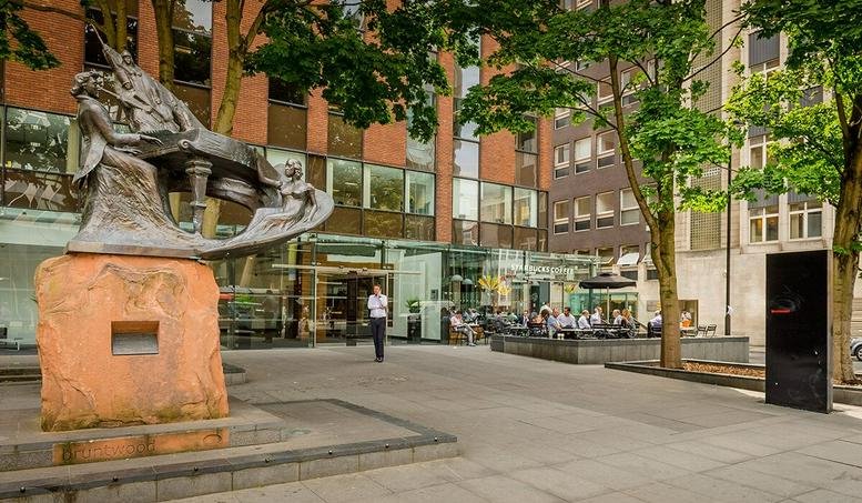Exterior entrance of Centurion House, 129 Deansgate with a large bronze sculpture and brick facade.