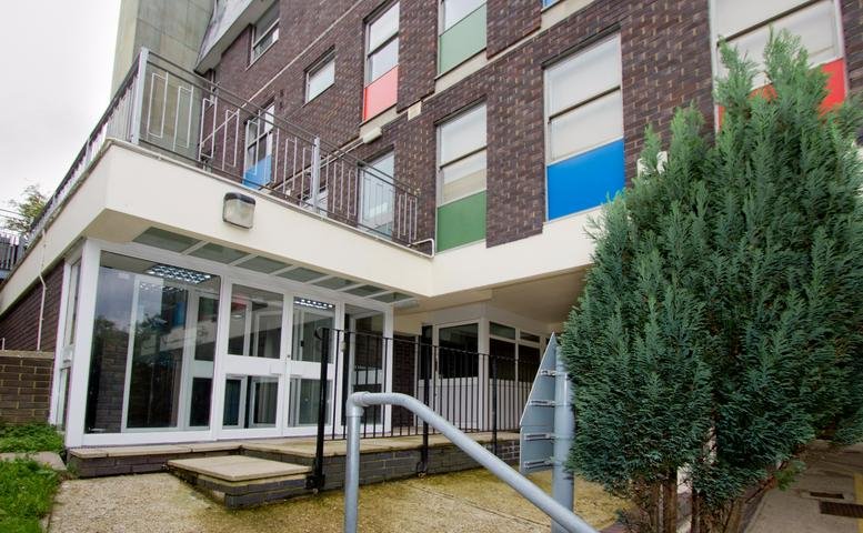 Exterior view of the brick facade and glass entrance at Century House, 100 Menzies Road.