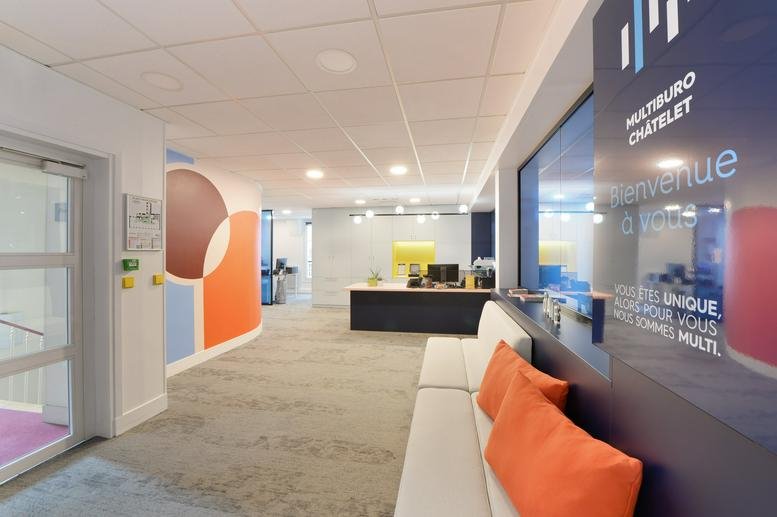 Spacious reception area with colorful wall art and branded signage at Chatelet, 52 Boulevard de Sebastopol.
