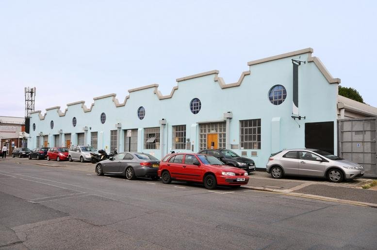 The industrial-style blue facade and saw-tooth roofline of Chiswick Studios, 9 Power Road.