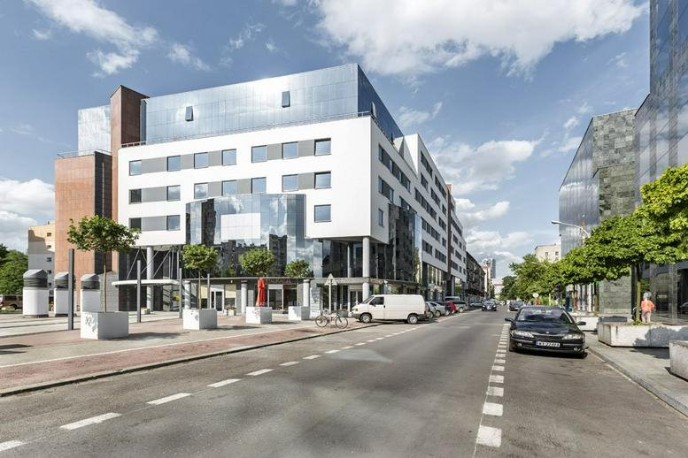 Modern exterior of the office building at Chmielna 132/134 Street, Warsaw, Poland with glass and white facade.