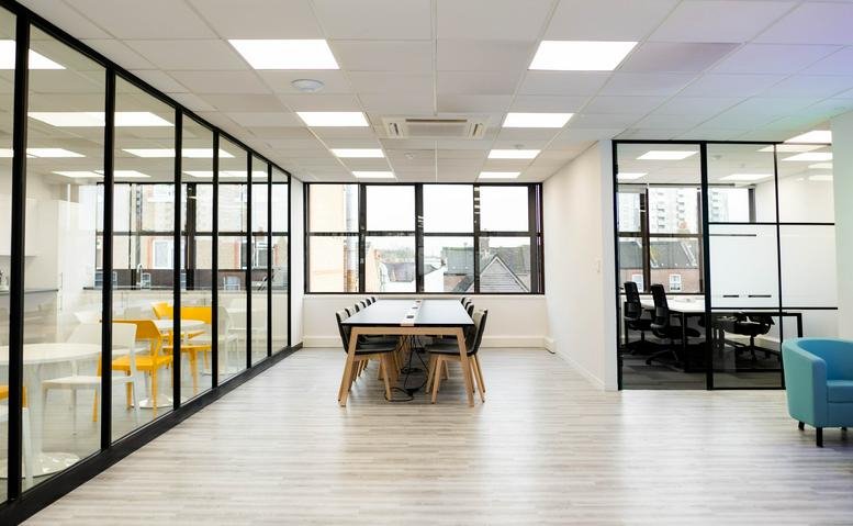 Bright lobby at Lux Offices, Victory House, featuring a meeting table and glass partitions.