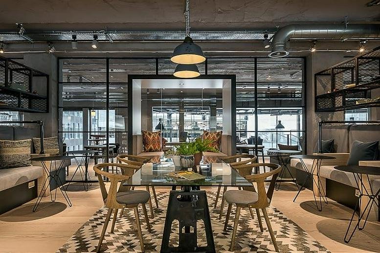Communal dining space at City Pavilion, Cannon Green with glass tables and industrial decor.
