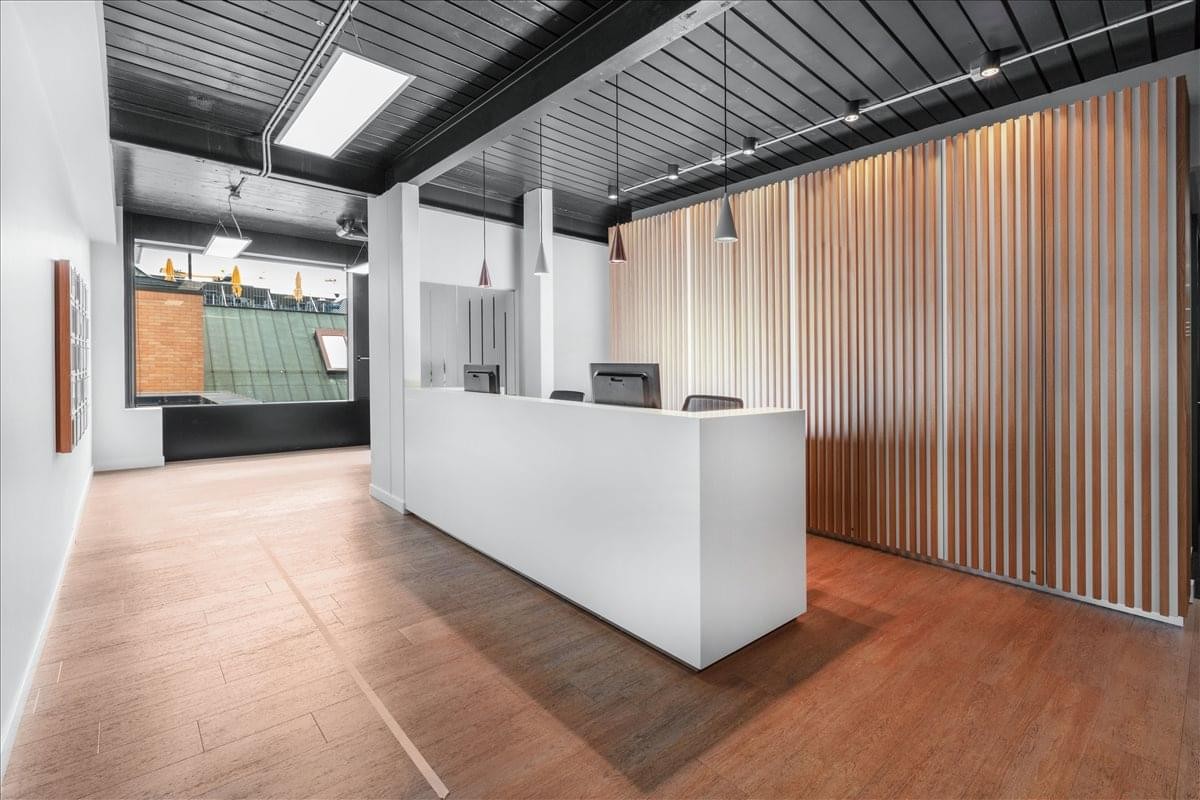 Modern reception area at Clarahuus, Teichgässlein 9, with white desk and vertical wood paneling.