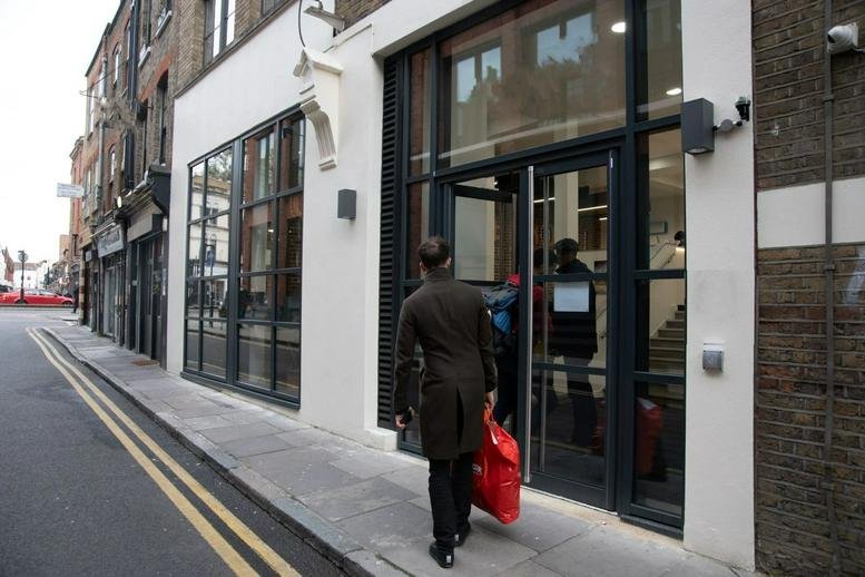 Exterior entrance of Coppergate House, 16 Brune Street with glass doors and white facade.