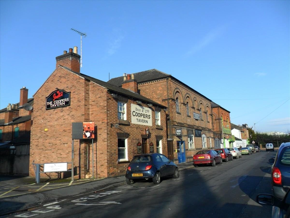 Exterior brick facade of the Cross Street Business Centre under a clear blue sky.