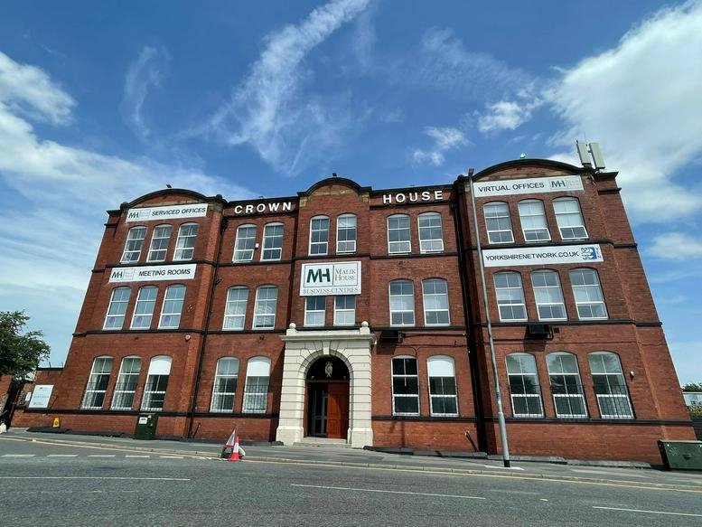 Wide-angle exterior view of the Crown House facade showing its classic brick architecture.