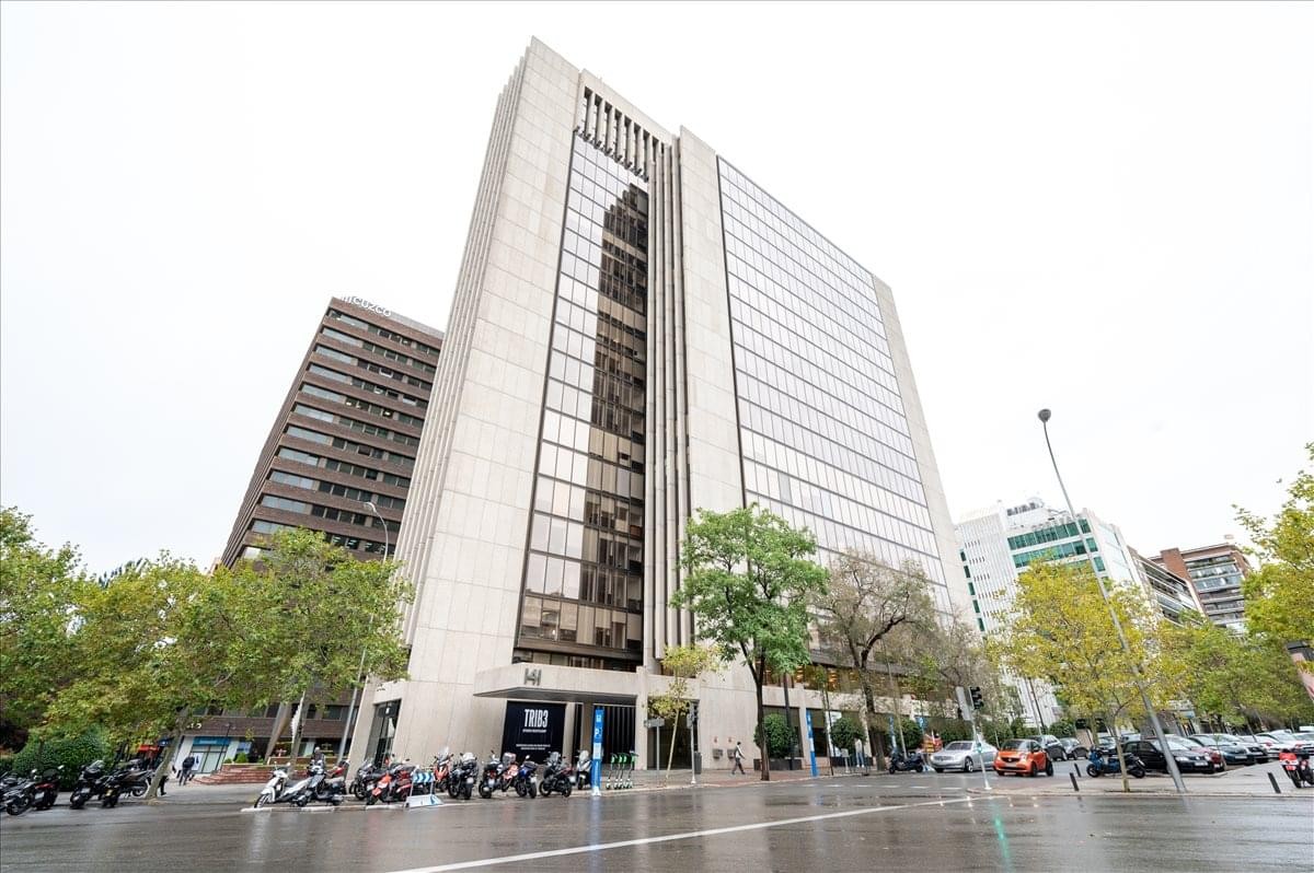 Exterior view of the towering stone and glass facade of the Cuzco IV building.