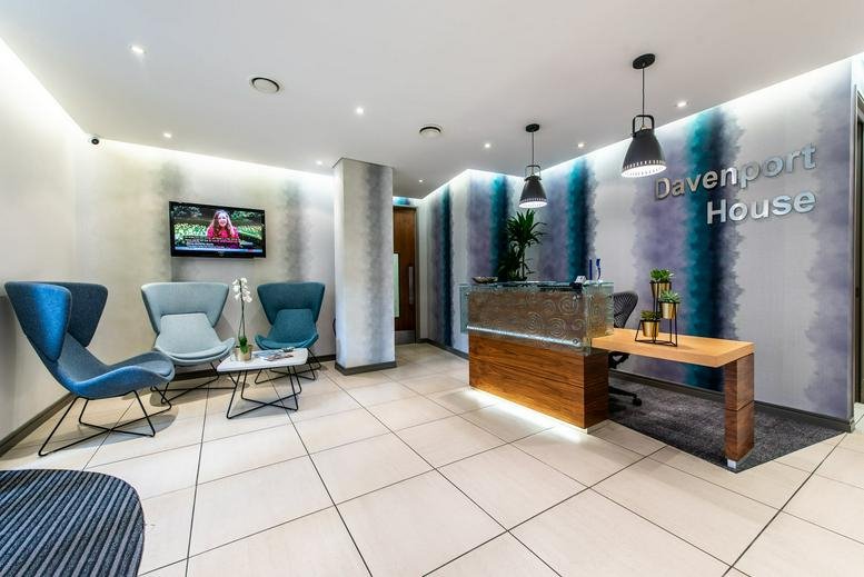 Bright, modern reception and lobby area at Davenport House with teal accents and lounge seating.