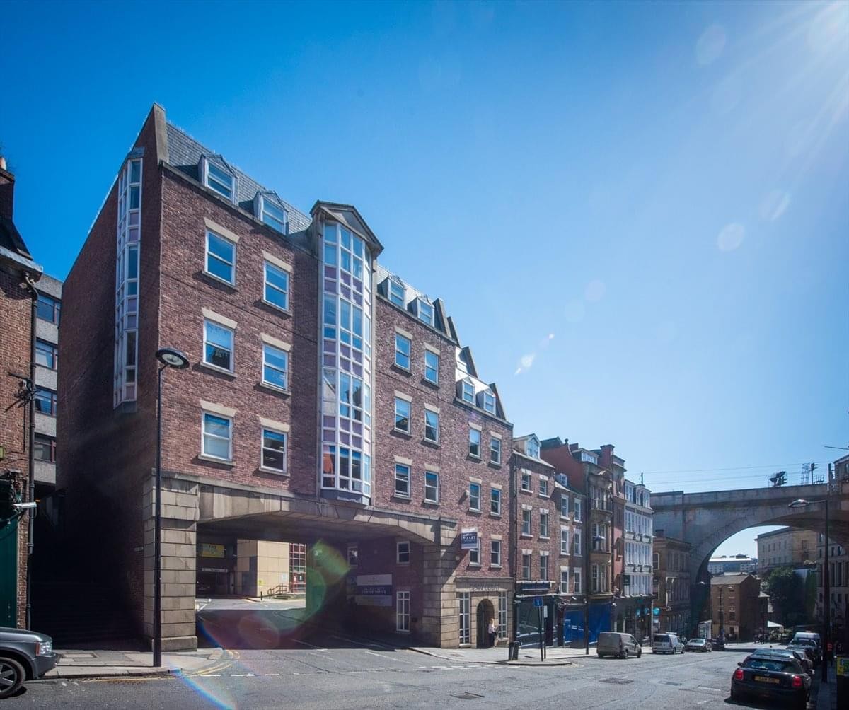 Exterior view of the brick facade at Dean Court, 22 Dean Street, with its prominent glass atrium.