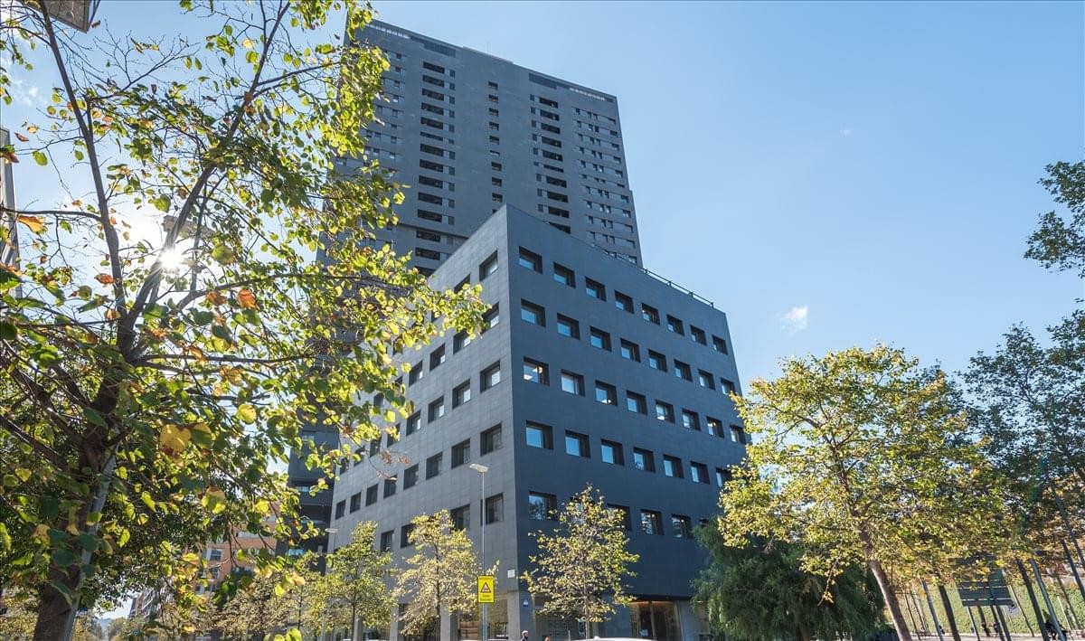 Exterior view of the modern grey and glass facade of the Diagonal Hightech building.