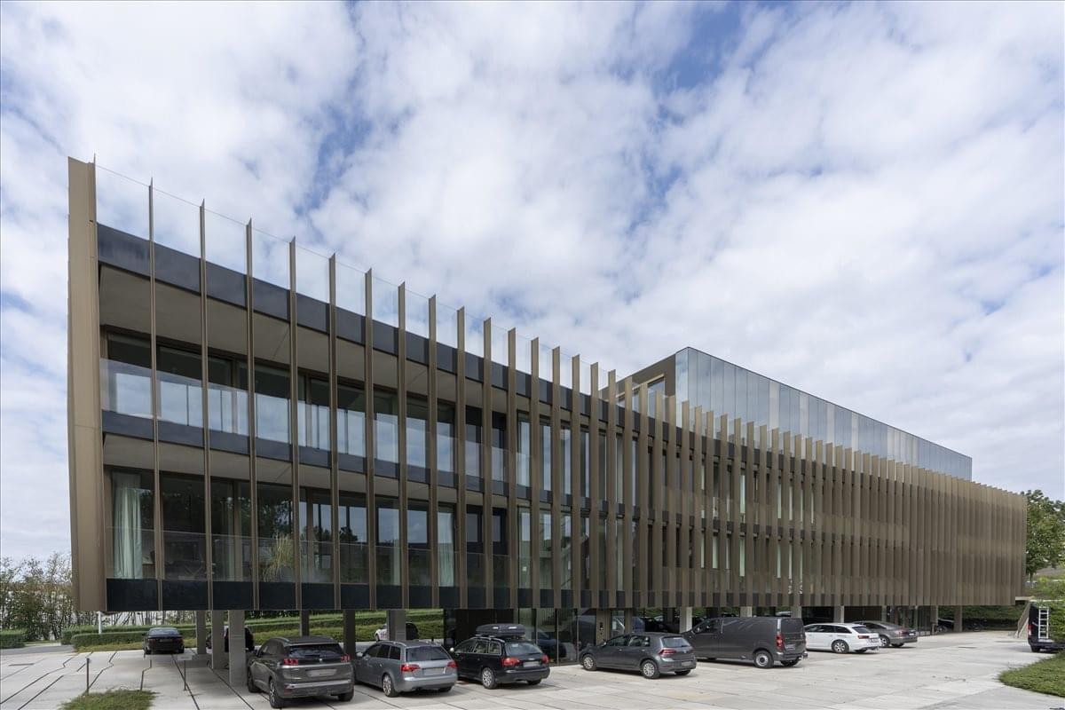 Exterior view of the modern glass and metal facade at Dumolinlaan 1, Brussels, Kortrijk.