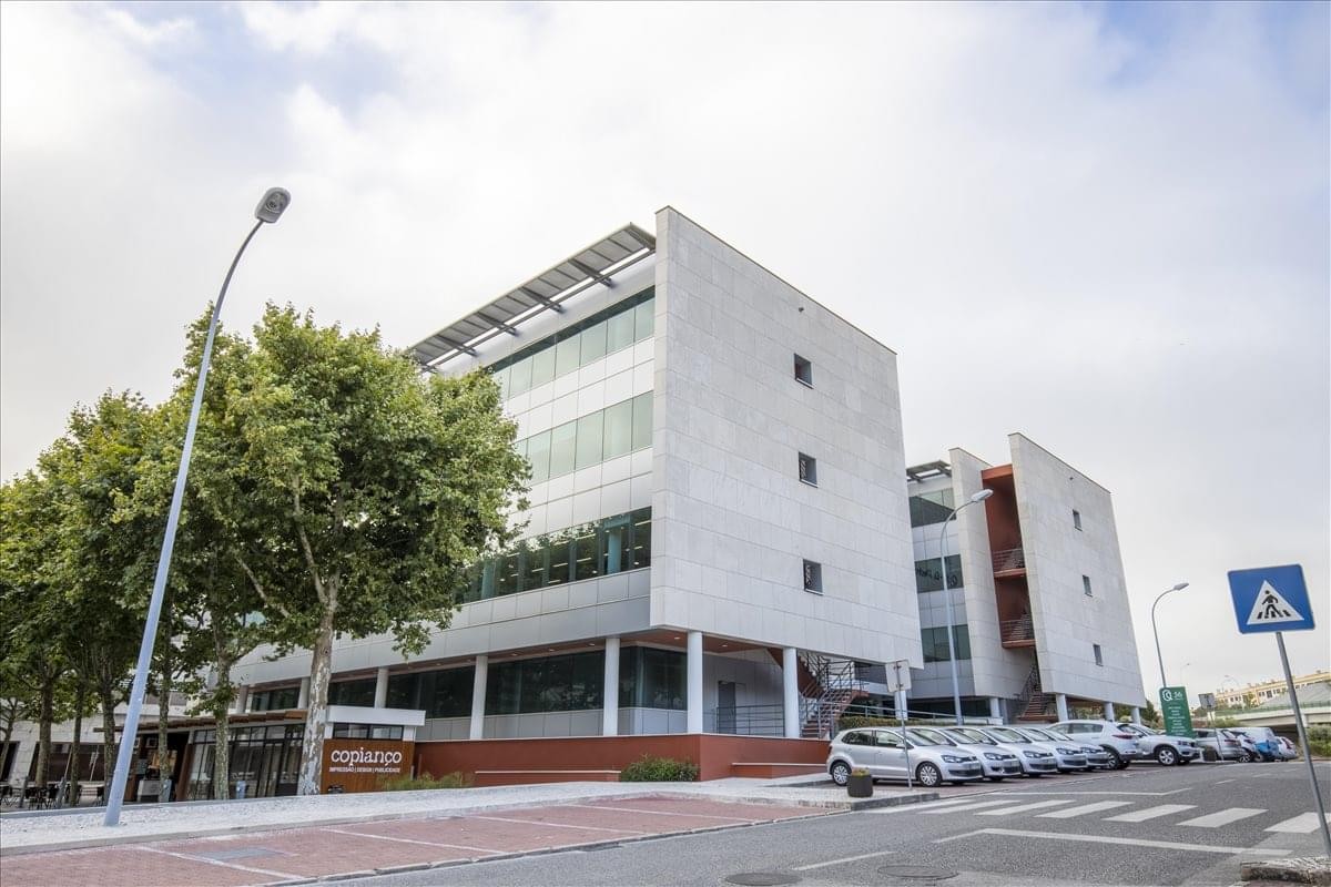 Exterior view of the contemporary white facade at Edificio Q56, Quinta da Fonte.