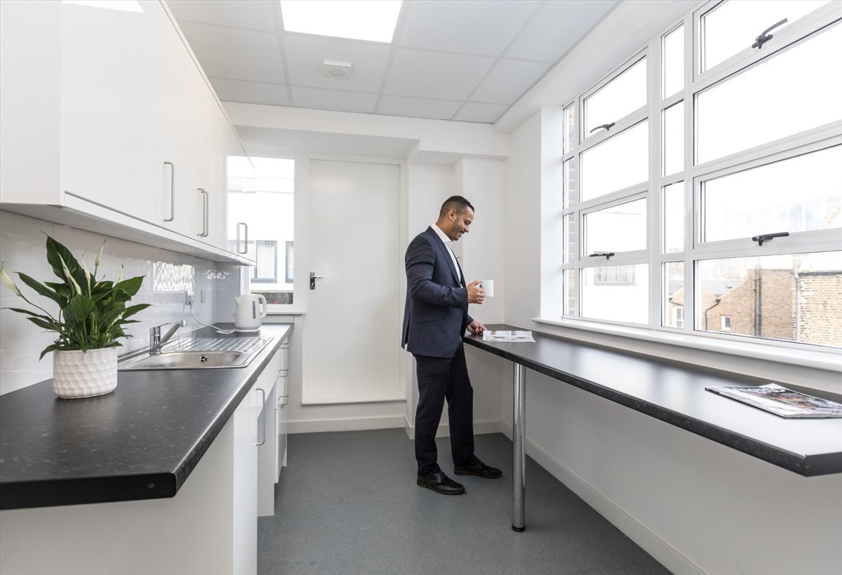 Communal kitchen area with black countertops and a businessman at 21 Effie Road.