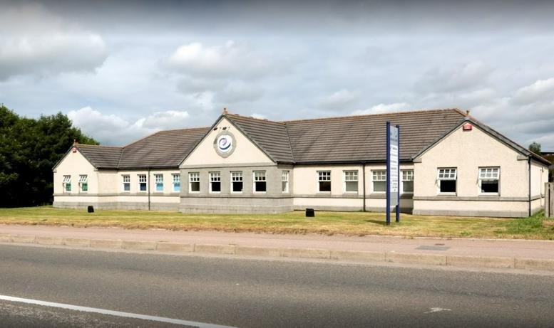 Wide exterior view of the building with signage and multiple windows.