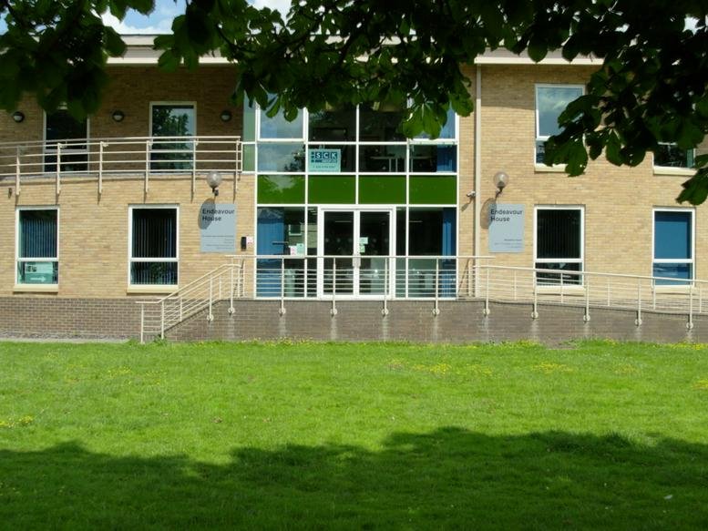 Exterior facade of Endeavour House, Building 50, featuring glass entrance and manicured lawn.