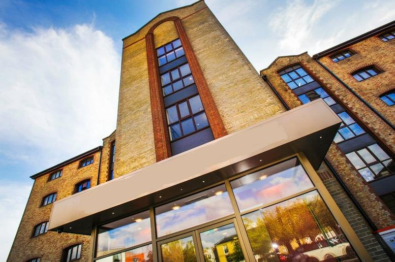 Low-angle view of Enterprise House, Ocean Village, showing the tall brick facade and glass entrance canopy.