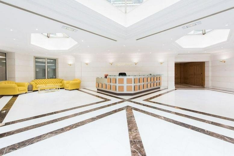 Spacious white lobby of Etoile, 121 Avenue des Champs Elysees, Paris, Paris Ile de France with a modern reception desk.