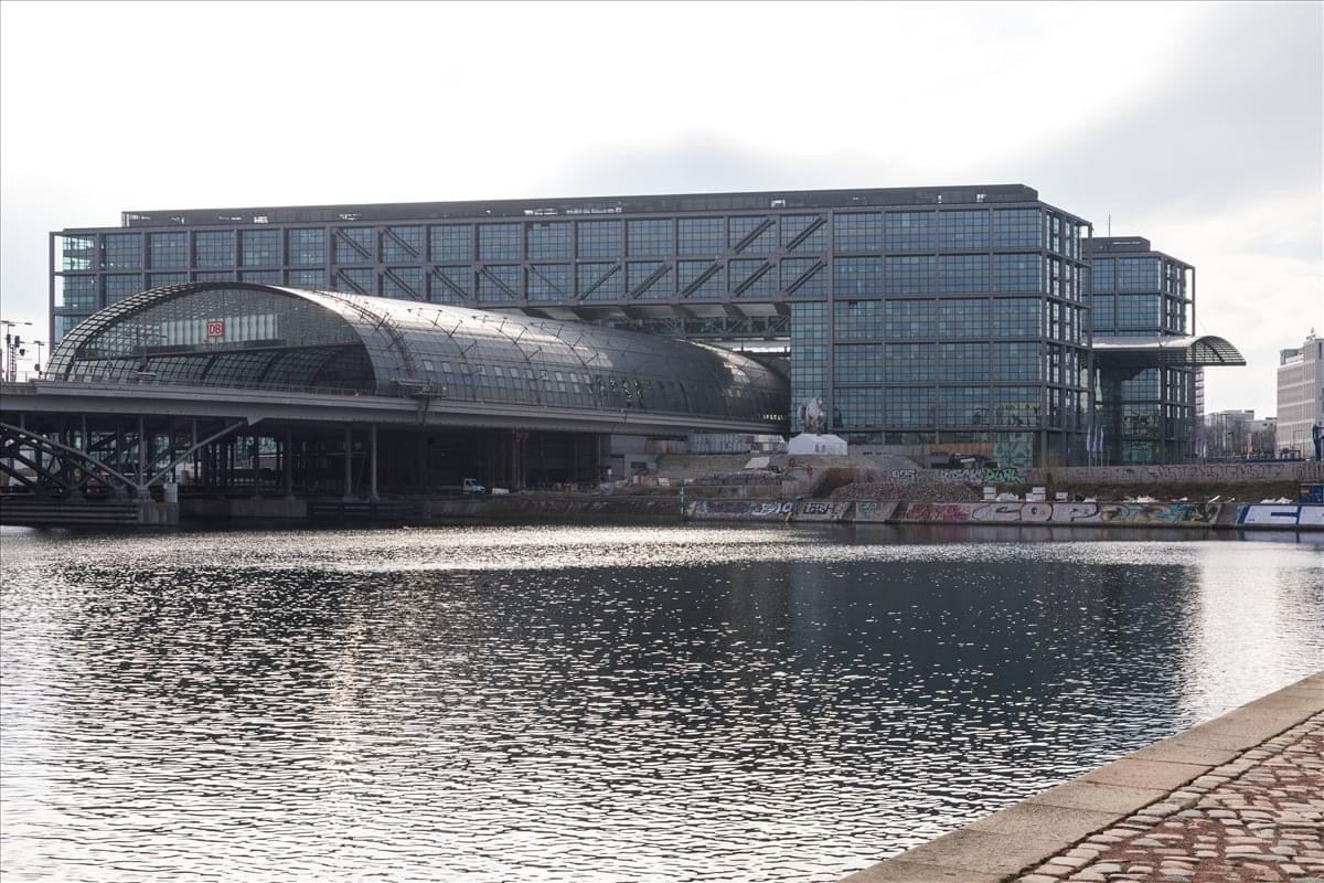 Modern glass exterior of the Europaplatz 2 office building overlooking the water.