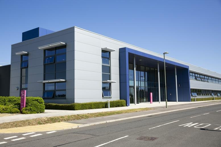 Modern exterior of Fareham Innovation Centre Merlin House with blue architectural accents and silver cladding.