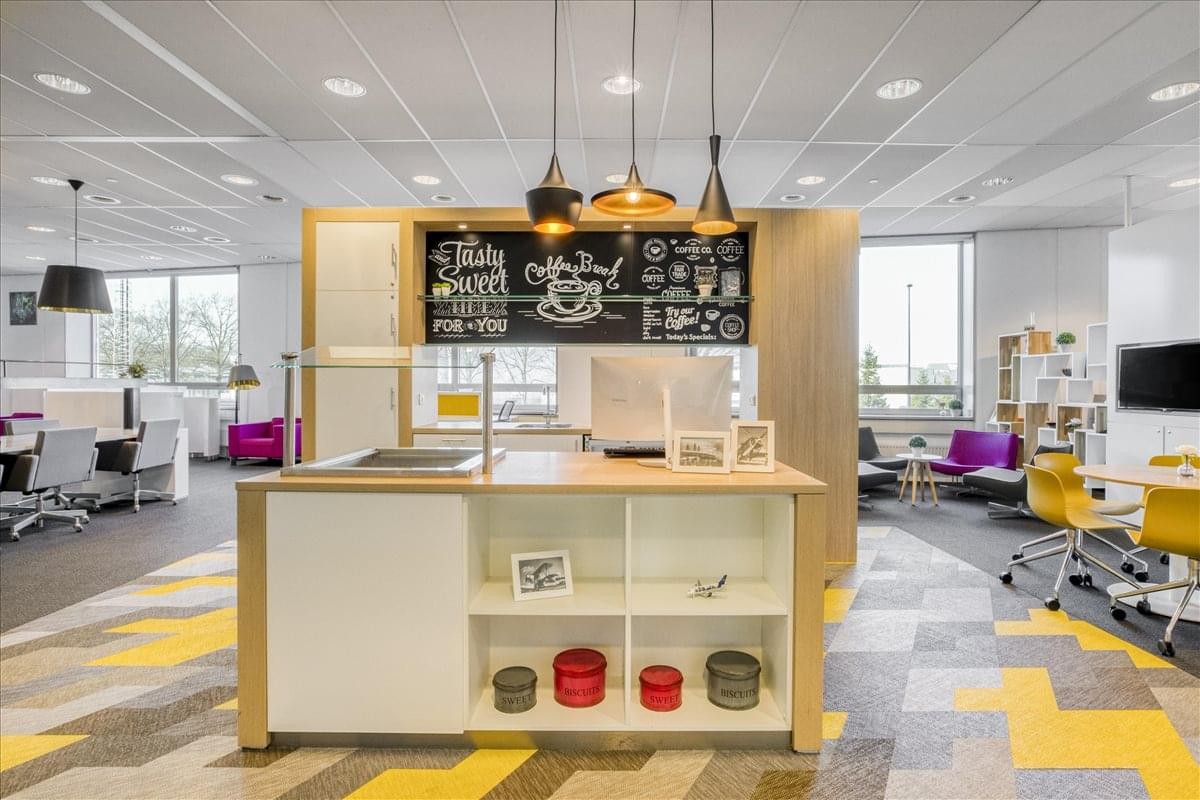 Spacious communal breakout area at Flight Forum 40 featuring a coffee bar, chalkboard wall, and colorful seating.
