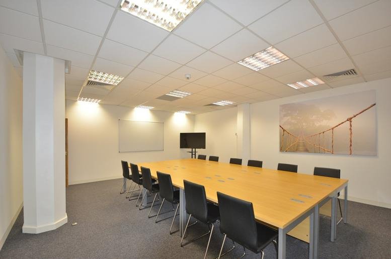 Spacious boardroom at Focal Point, 27-35 Fleet Street with a long wooden table and professional black chairs.