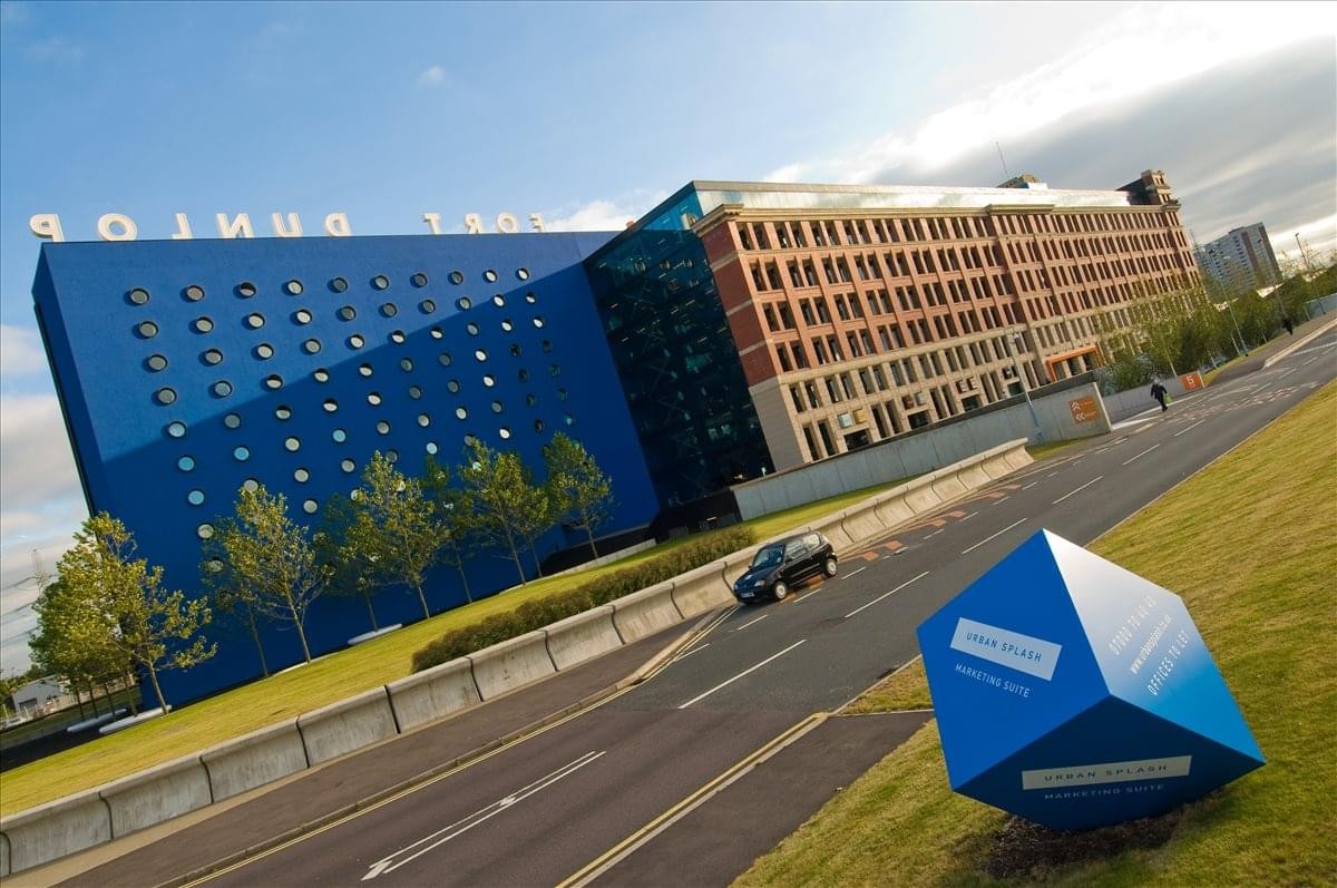 Exterior of the iconic Fort Dunlop building with its distinctive blue facade and brick architecture.