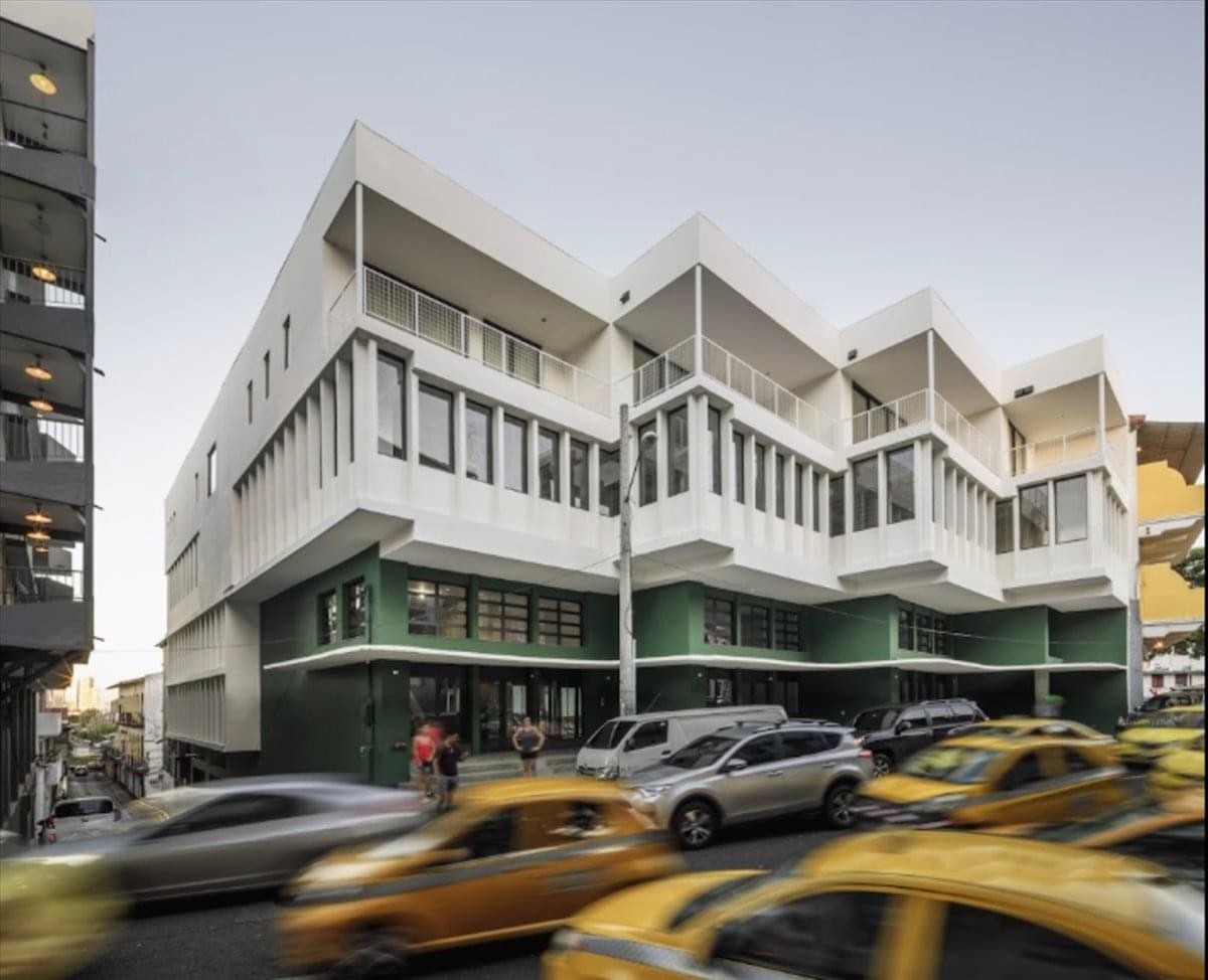 Modern white building exterior at Friedrichstraße 15 with green accents on the ground floor.