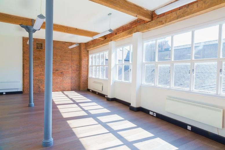 Spacious, sunlit open-plan office at Gainsborough House, 109 Portland Street, Manchester with exposed brick and timber beams.