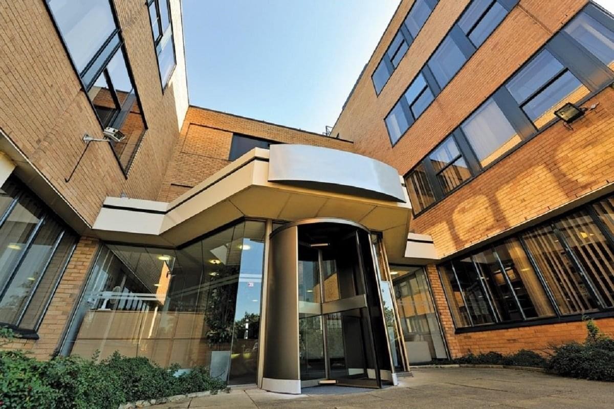 Close-up view of the modern revolving glass entrance at Gateway House, Styal Road, Manchester.
