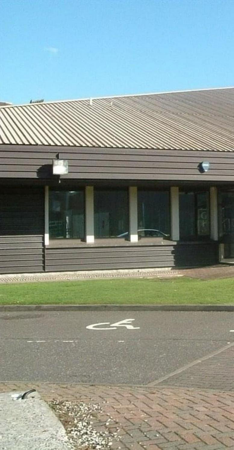 Exterior view of the brown-clad facade of Geddes House Business Centre with a metal roof and large windows.