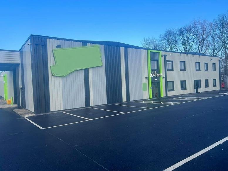 Exterior view of the Gladden Place, Unit 17 office building with a modern grey facade and green accents.