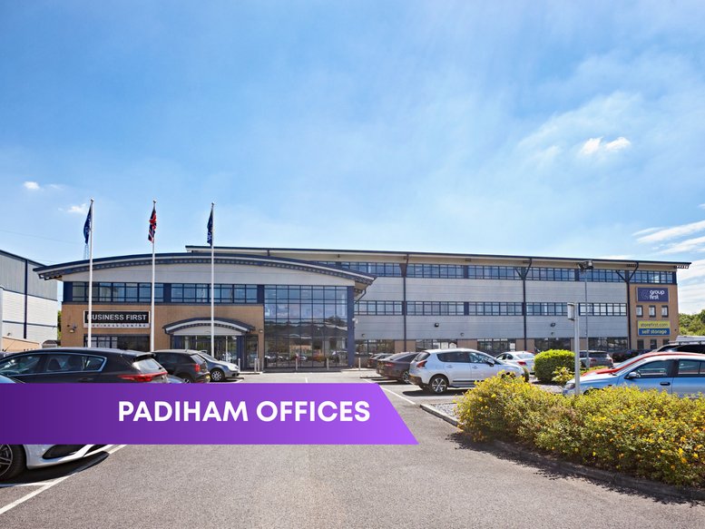 Exterior view of the multi-story Group First House building with a large parking lot.