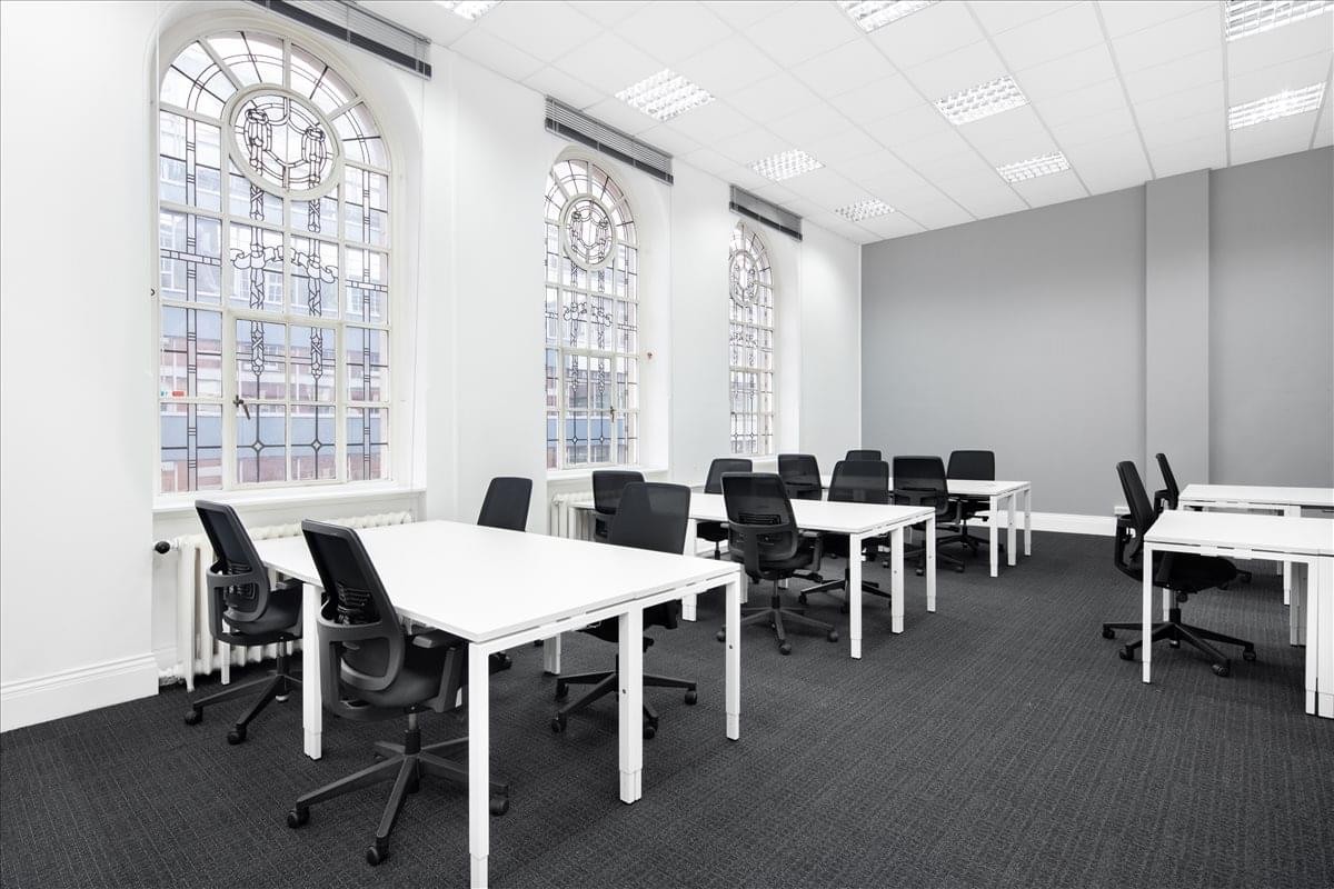 Spacious open-plan workspace at Hamilton House with large arched windows and white desks.