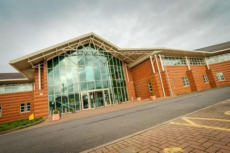 Exterior view of the brick and glass facade at Harry Weston Road, Coventry.