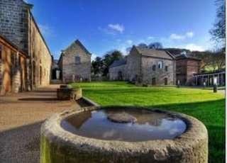 Exterior view of the historic stone buildings at Hathersage Hall Business Centre with a central courtyard.