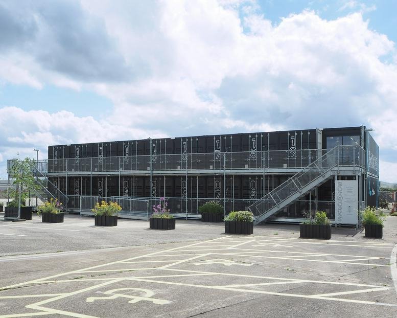 Exterior of the two-story modular Boxworks at Brabazon building made from black shipping containers.