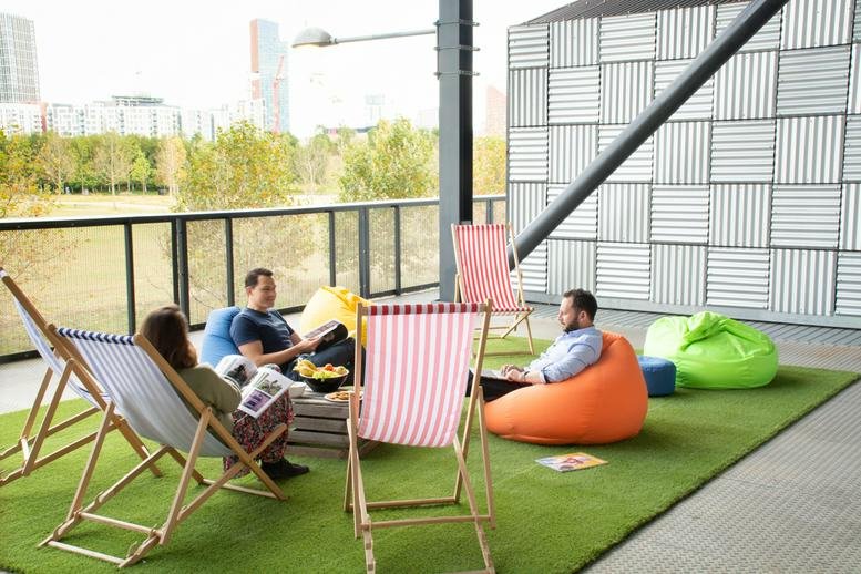 Rooftop terrace lounge with deck chairs and beanbags on artificial grass at Here East.